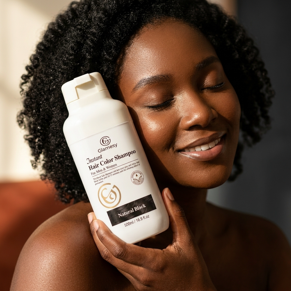 Woman holding Glamesy shampoo bottle to her curly black hair